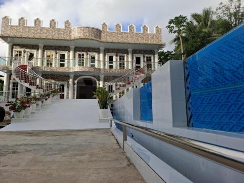 an exterior view of a large building with a staircase at Siquijor Island Castle Resort in Lazi