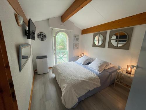 une chambre avec un lit et une grande fenêtre dans l'établissement Villa du Lac,, à Biscarrosse