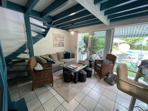 un salon avec un canapé et des chaises dans l'établissement Villa du Lac,, à Biscarrosse