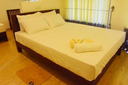 une chambre avec un lit avec deux serviettes dessus dans l'établissement Pepper Garden Cottage, à Uda Walawe