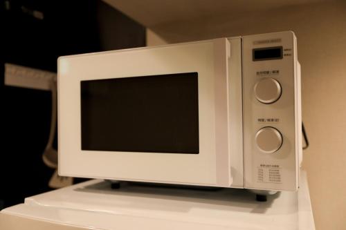 a white microwave oven sitting on top of a counter at 5 minutes on foot from tokyo Asakusa Station!A beautiful house that has been fully renovated in 2024 for one group per day東京雷門から徒歩4分1日1組限定貸切2024年全面リフォーム済みの綺麗な一軒家 in Tokyo