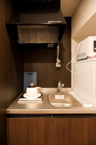 a kitchen counter with a sink and a microwave at 5 minutes on foot from tokyo Asakusa Station!A beautiful house that has been fully renovated in 2024 for one group per day東京雷門から徒歩4分1日1組限定貸切2024年全面リフォーム済みの綺麗な一軒家 in Tokyo