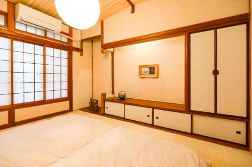 a bedroom with a large bed and windows at 5 minutes on foot from tokyo Asakusa Station!A beautiful house that has been fully renovated in 2024 for one group per day東京雷門から徒歩4分1日1組限定貸切2024年全面リフォーム済みの綺麗な一軒家 in Tokyo
