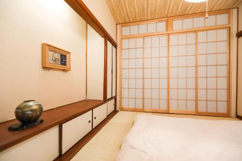 a room with a bed and a vase on a table at 5 minutes on foot from tokyo Asakusa Station!A beautiful house that has been fully renovated in 2024 for one group per day東京雷門から徒歩4分1日1組限定貸切2024年全面リフォーム済みの綺麗な一軒家 in Tokyo