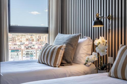 a bedroom with a bed and a large window at ANSA Beach Apartments - Malaga - Skyline Suite in Málaga