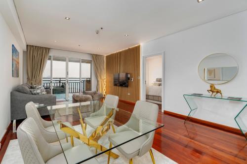 a living room with a glass table and chairs at FULL SEA VIEW Burj AlArab and Burj Khalifa, Private Beach, 5 Stars Resort The Palm Jumeirah in Dubai