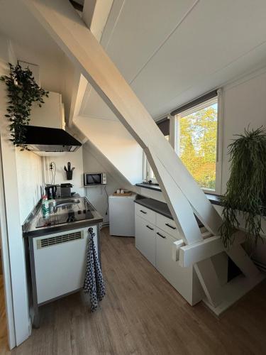 a kitchen with a staircase in a tiny house at Studio 131 in Eindhoven