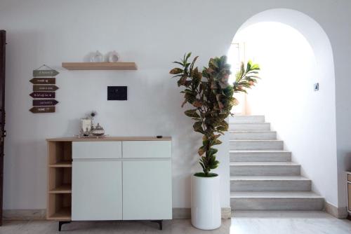 a staircase with a white cabinet and a plant at The Lavish Affair in Bhuj