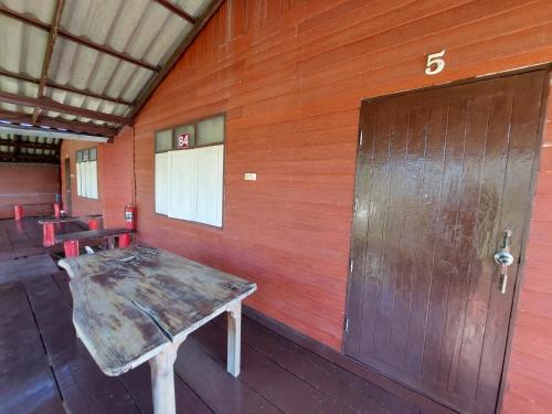 una camera con una parete in legno e una porta in legno di IngTawan Resort อิงตะวัน รีสอร์ท a Sing Buri