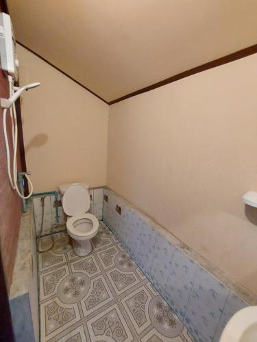 a bathroom with a toilet and a bath tub at IngTawan Resort อิงตะวัน รีสอร์ท in Sing Buri