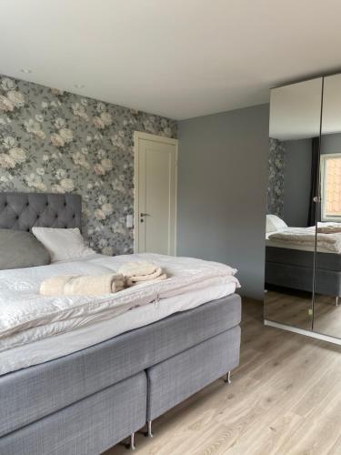 a bedroom with a large bed and a mirror at Villa Valjensa in Sölvesborg