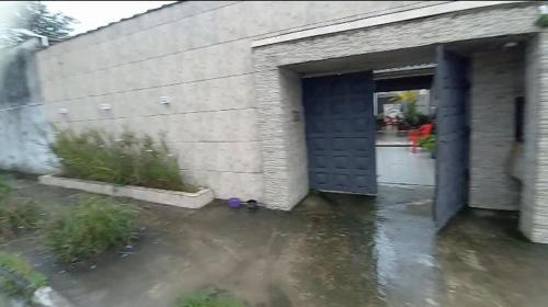 eine überflutete Garage mit blauer Tür und Wasser in der Unterkunft Casa em carragua in Caraguatatuba