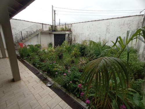 einen Garten mit Blumen und Pflanzen in einem Gebäude in der Unterkunft Casa em carragua in Caraguatatuba