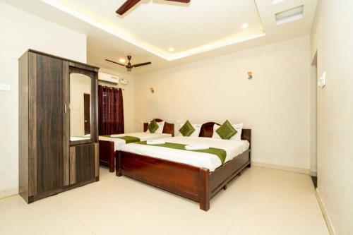 a bedroom with two beds and a mirror at Hotel Ramleela in Rāmeswaram