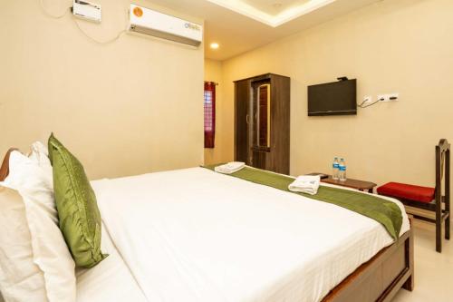 a bedroom with a bed and a tv on the wall at Hotel Ramleela in Rāmeswaram