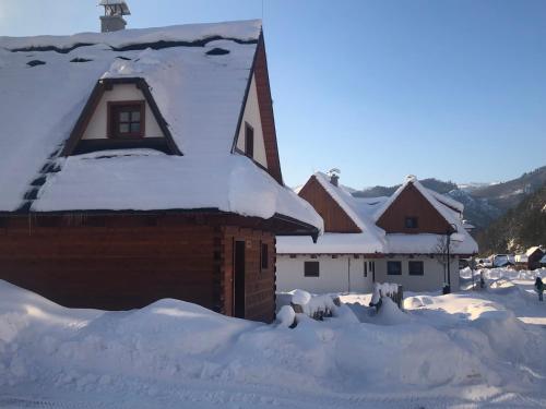 a house covered in snow with a roof at Zaži Chalupa Liptovska Osada in Liptovská Osada