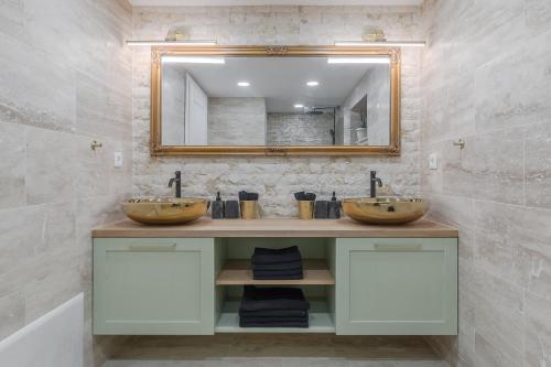 een badkamer met twee wastafels en een spiegel bij Olive Apartment 1 - w Free Parking, self-checkin, 5 min from Aquapark Nymphaea in Oradea