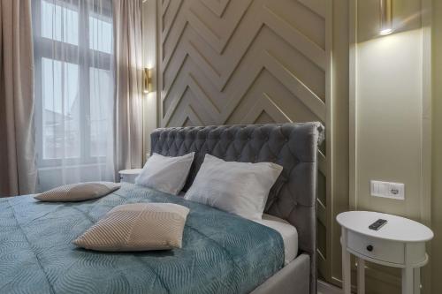 a bed with two pillows on it in a room at Olive 1 - w Free Parking, self-checkin, 5 min from Aquapark Nymphaea in Oradea