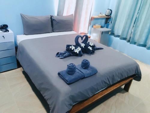 a bed with two towels and a pair of scissors at Baan Suan Sunset in Ban Laem Sai