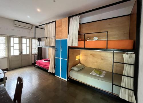 a room with a bunk bed and a room with a desk at The Patio Yogya in Yogyakarta