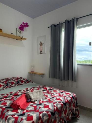a bedroom with a bed and a window at Cantinho da Rasa in Cabo Frio