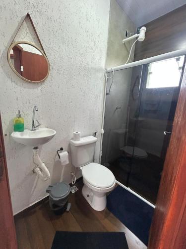 a bathroom with a toilet and a sink and a shower at Cantinho da Rasa in Cabo Frio