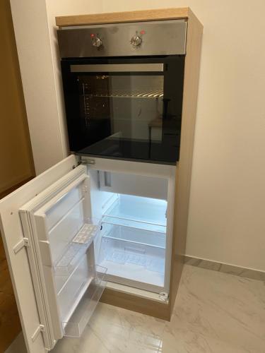 an empty refrigerator with its door open in a room at Apartments Y Edelhof in Saalfeld