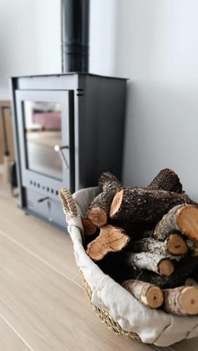 a basket of logs in front of an oven at Casa rural La Pinada in Villanueva de Viver