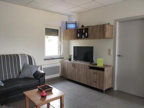 un soggiorno con divano e TV a schermo piatto di Maisonjoske a Beaulieu