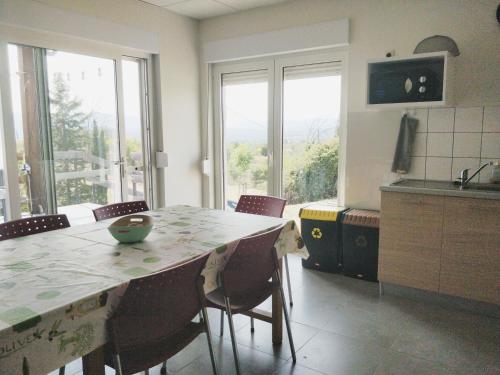 Il comprend une cuisine avec une table et des chaises. dans l'établissement Maisonjoske, à Beaulieu