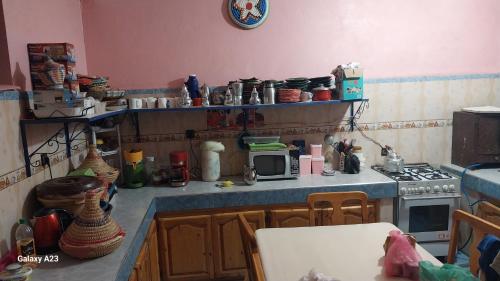 a kitchen with a stove and a microwave at Maroc Galacx in Ouarzazate