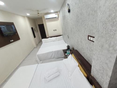 a room with two beds and a wall at Ginger hotels ujjain tower kshipra inn-Family stay airconditioned hotel in Ujjain