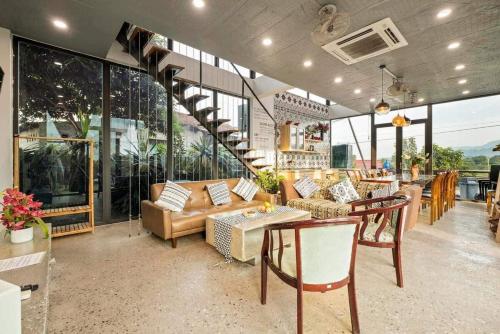 a living room with couches and tables and windows at Nắng Villa - Greenfield Villas in Ba Vì