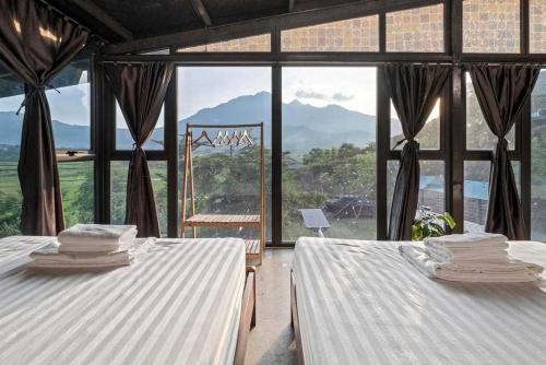 two beds in a room with a large window at Nắng Villa - Greenfield Villas in Ba Vì