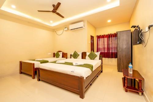 a bedroom with two beds and a ceiling fan at Hotel Ramleela in Rāmeswaram