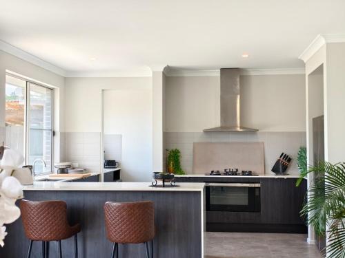 una cocina con encimera y algunas sillas. en Countryside Hilltop Stay near Gympie, en Corella