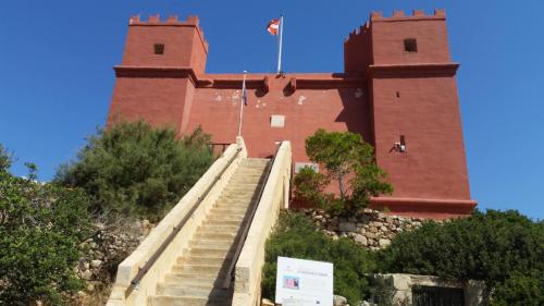 a large red brick building with stairs in front of it at Side Sea View D, Steps Away to Bugibba Jetty, For the Blue Lagoon Boats and Other Islands in St Paul's Bay