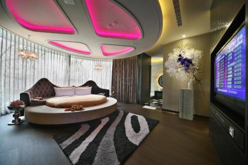 a bedroom with a large bed and a tv at Han Guan Motel in Taichung