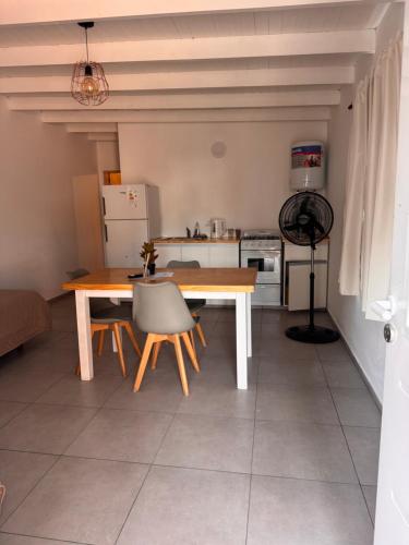 Una cocina con una mesa y sillas de madera en una habitación. en Dpto 4 pers, en Monte Hermoso