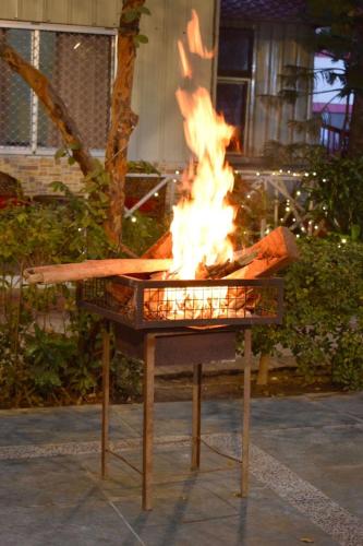 a grill with a fire in it on a sidewalk at Sudhaksha Celebrations in Prayagraj