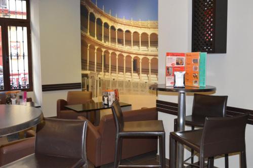 un restaurant avec des tables et des chaises et un tableau de théâtre dans l'établissement Plaza de Toros, à Ronda
