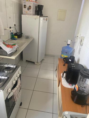 a kitchen with a stove and a refrigerator in it at Comfortable apartment in Barra dos Coqueiros