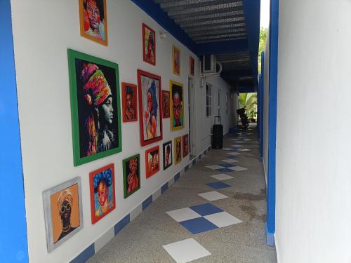 a hallway with a bunch of paintings on a wall at Casa Skyros in Arboletes