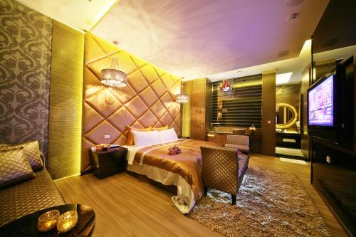 a hotel room with a bed and a television at Han Guan Motel in Taichung