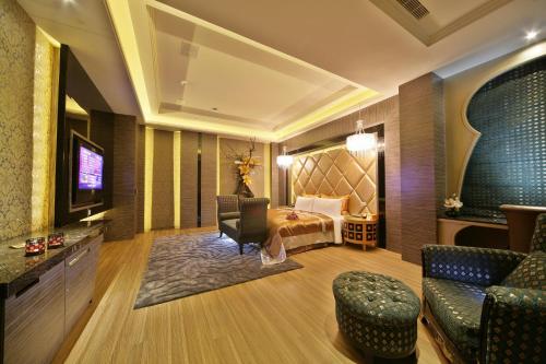 a hotel room with a bed and a television at Han Guan Motel in Taichung