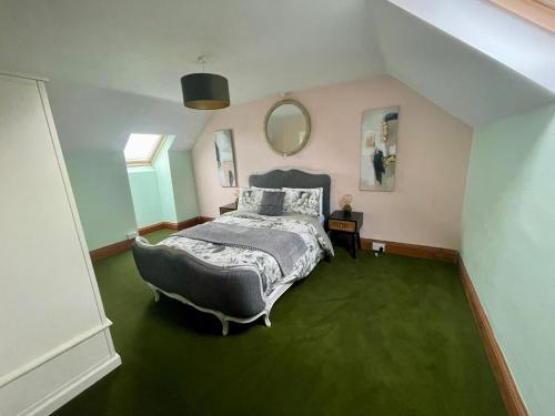 a bedroom with a bed and a large mirror at Rhianfa 4 bedroom house minutes walk from the beach in New Quay