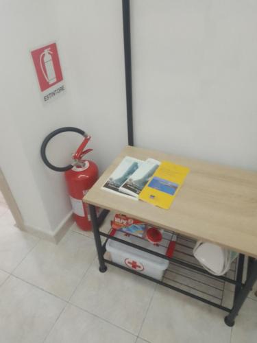 a table with a bench next to a table with a fire extinguisher at Carpe Diem da Salvina in Pachino