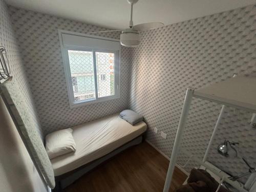 a small room with a bed with a window at Practical and cozy AP - Tatuapé Prox ao Metro in Sao Paulo