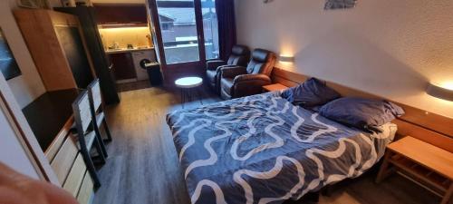 une petite chambre avec un lit et une chaise dans l'établissement Appartement en résidence Brides les Bains, à Brides-les-Bains