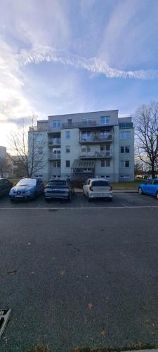 a parking lot with cars parked in front of a building at Luxury Apartmen by airport in Pardubice